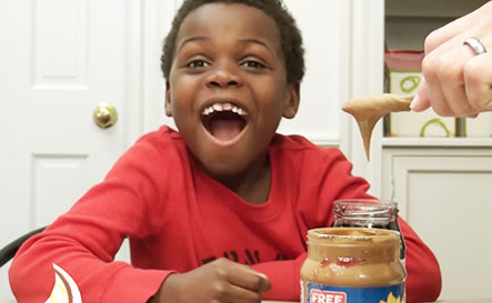 A boy smiling at peanut butter.
