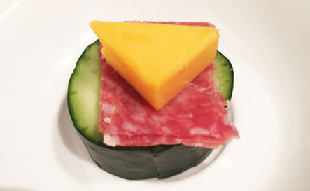 A cucumber with salami and cheese.